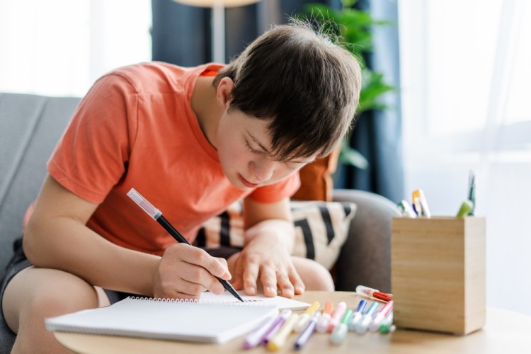 A disable boy writing